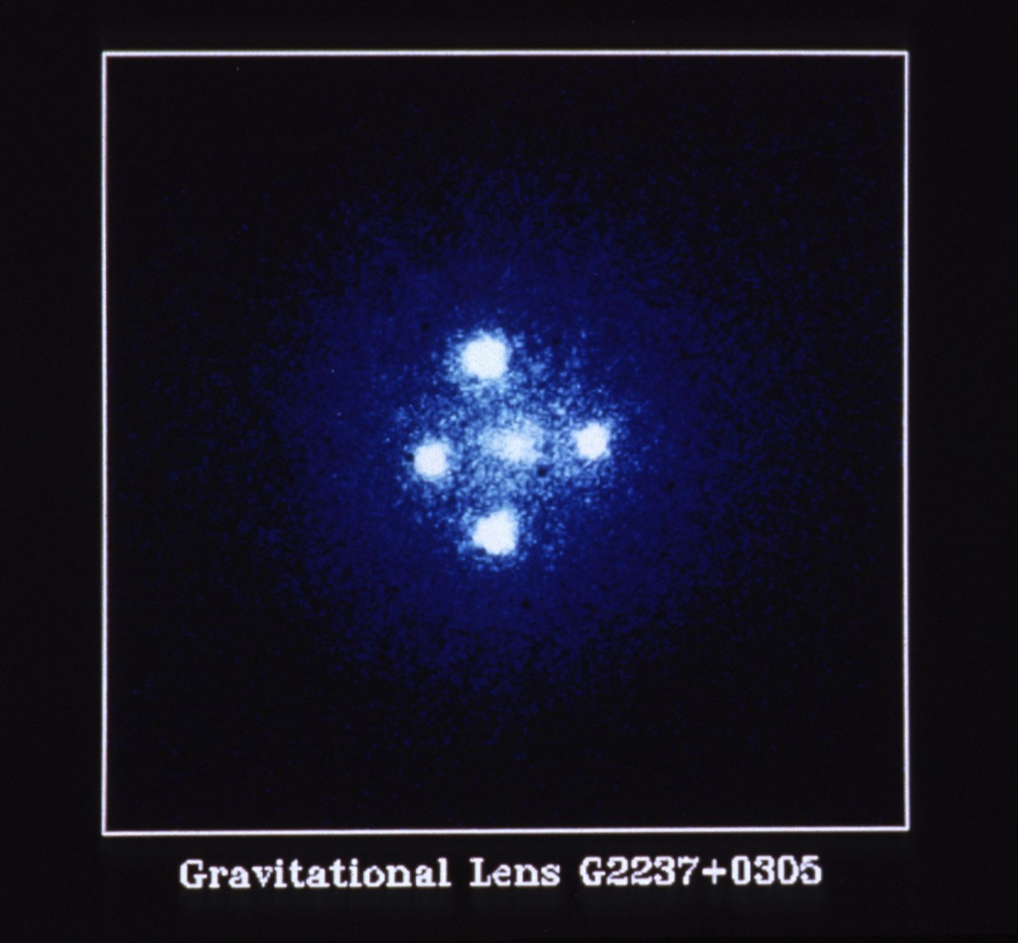 NASA/ESAハッブル宇宙望遠鏡が撮影した重力レンズG2237+0305（アインシュタインの十字架）。一つのクエーサーが前景銀河の周囲に4像として見える。